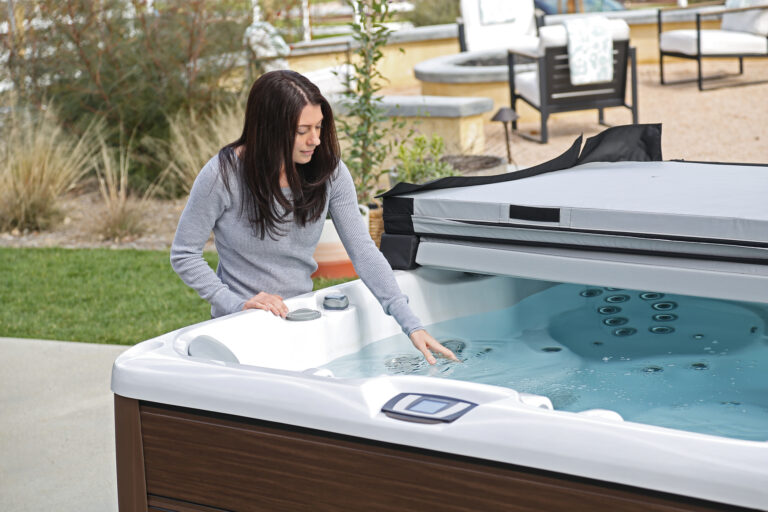 Woman checking the water temperature and adding hot tub chemicals before hot tub cleaning