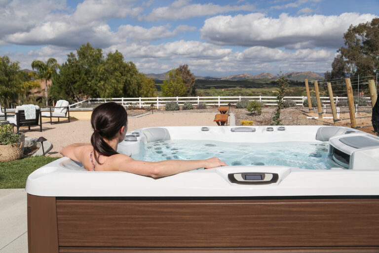 girl relaxing in backyard hot tub