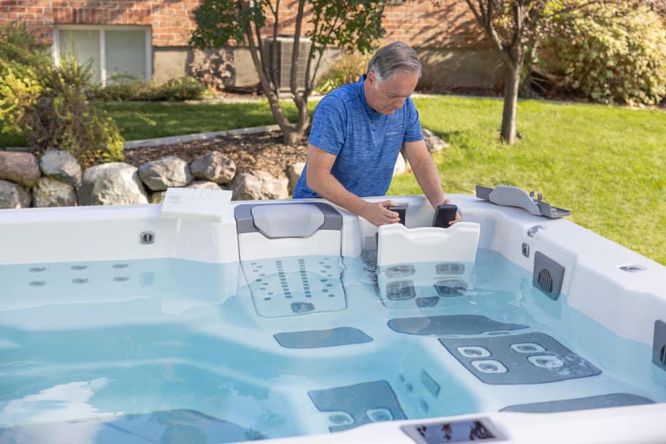 Man changing one of the JetPaks in a Bullfrog swim spa - small swim spas