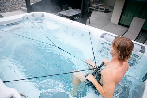 backyard swim spas - man working out in a Bullfrog swim spa