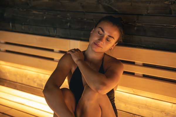 using a sauna after workouts - women stretching in sauna 